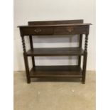 An early 20th century buffet with two drawers to top above two shelves with barley twist supports.