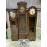 Three early 20th century longcase clocks with eight brass weights and four pendulums. H:225cm