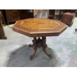 An inlaid walnut veneered octagonal table on ceramic castors