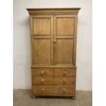 A Victorian pine house keepers cupboard with large double doors to shelves above chest base with