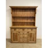 A Large farmhouse Victorian pine dresser with plate racks and brass hooks, base with four central