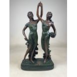 A Resin statue of a pair of ladies on plinth.W:34cm x D:15cm x H:59cm