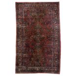 A large Oriental woollen rug, floral decorated, 306 x 511 cm