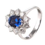 An 18ct white gold ring, central set with an oval cut sapphire and furthermore all-around mounted wi