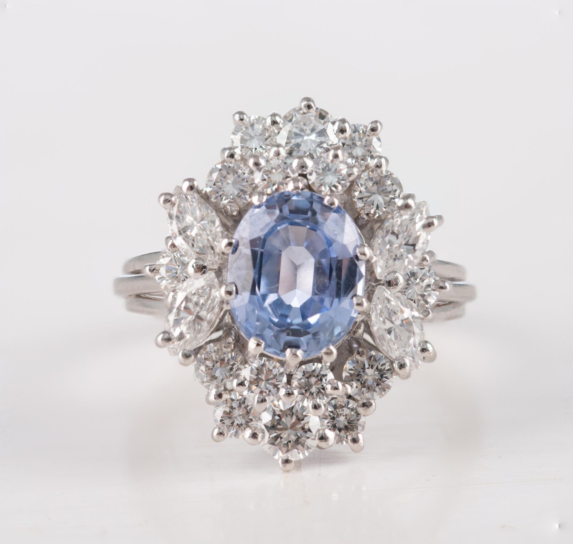 An 18ct white gold ring, central set with an oval cut sapphire and furthermore all-around mounted wi - Image 2 of 3