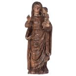 A walnut sculpture of the standing Madonna holding the Holy Child, with traces of polychrome paint,