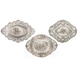 A collection of three silver chargers with ornate repousse pierced work, the well depicting playing