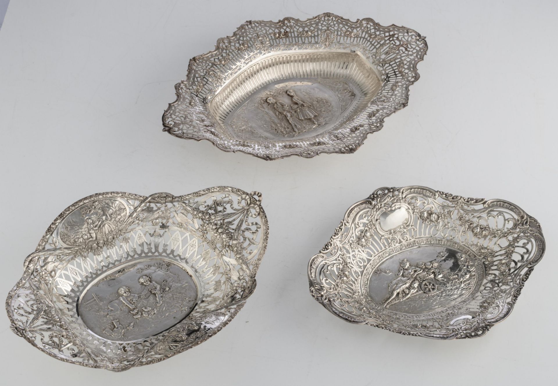 A collection of three silver chargers with ornate repousse pierced work, the well depicting playing - Bild 8 aus 12