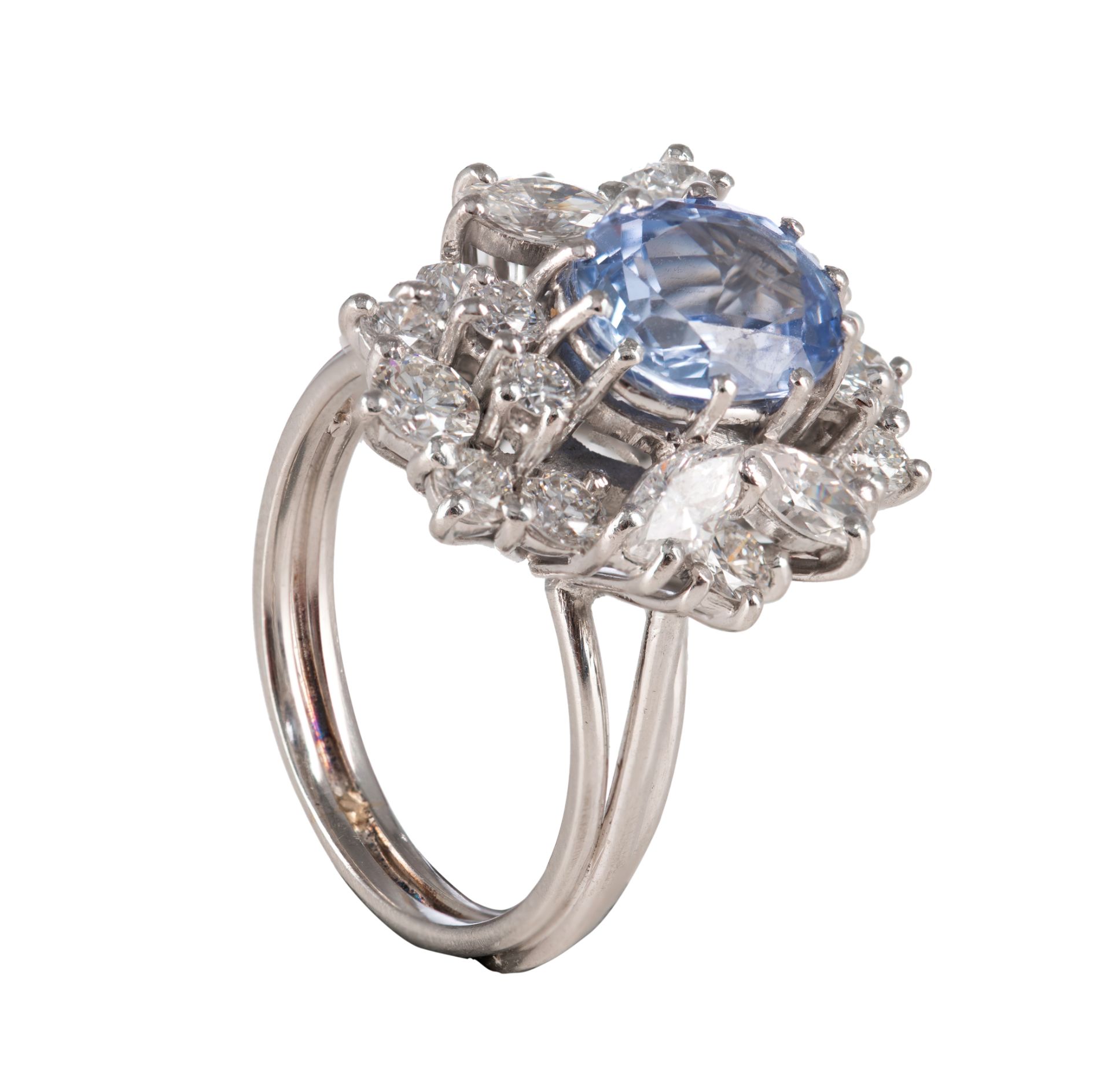 An 18ct white gold ring, central set with an oval cut sapphire and furthermore all-around mounted wi