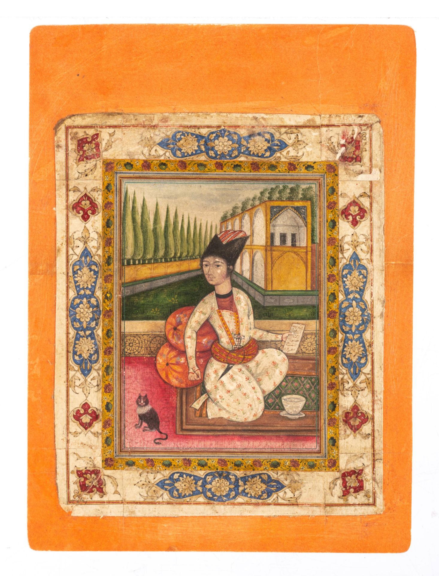 A Persian 19thC gouache painting on paper depicting an elegantly dressed Qajar youth holding a pen a - Image 2 of 5