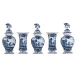 A blue and white relief decorated Delftware five-piece garniture, with on top bird-shaped knobs, the