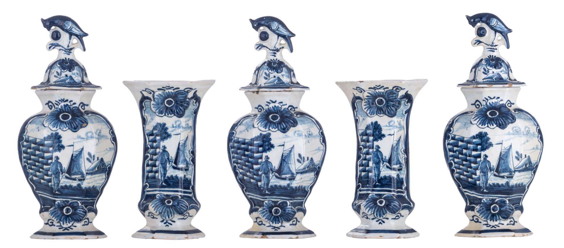 A blue and white relief decorated Delftware five-piece garniture, with on top bird-shaped knobs, the