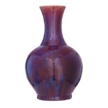 A Chinese sang-de-boeuf bottle vase, flamb‚-glazed in dark purplish-red tone with pale blue streaks,