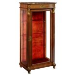 A mahogany veneered Empire style display cabinet, flanked by two caryatides, decorated with gilt bro