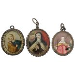 Three various recto-verso devotional pendant reliquaries with relics of St. Peter, St. Theresa, and