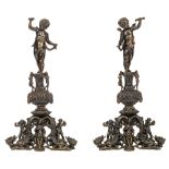 An impressive pair of Renaissance style patinated bronze andirons, topped with winged putti above an