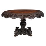 A richly carved Anglo-colonial exotic hardwood centre table, the openworked sides floral decorated,