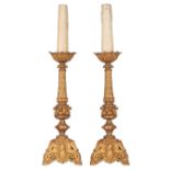 A pair of gilt bronze Romanesque inspired horror vacui candleholders, decorated with semi-precious s