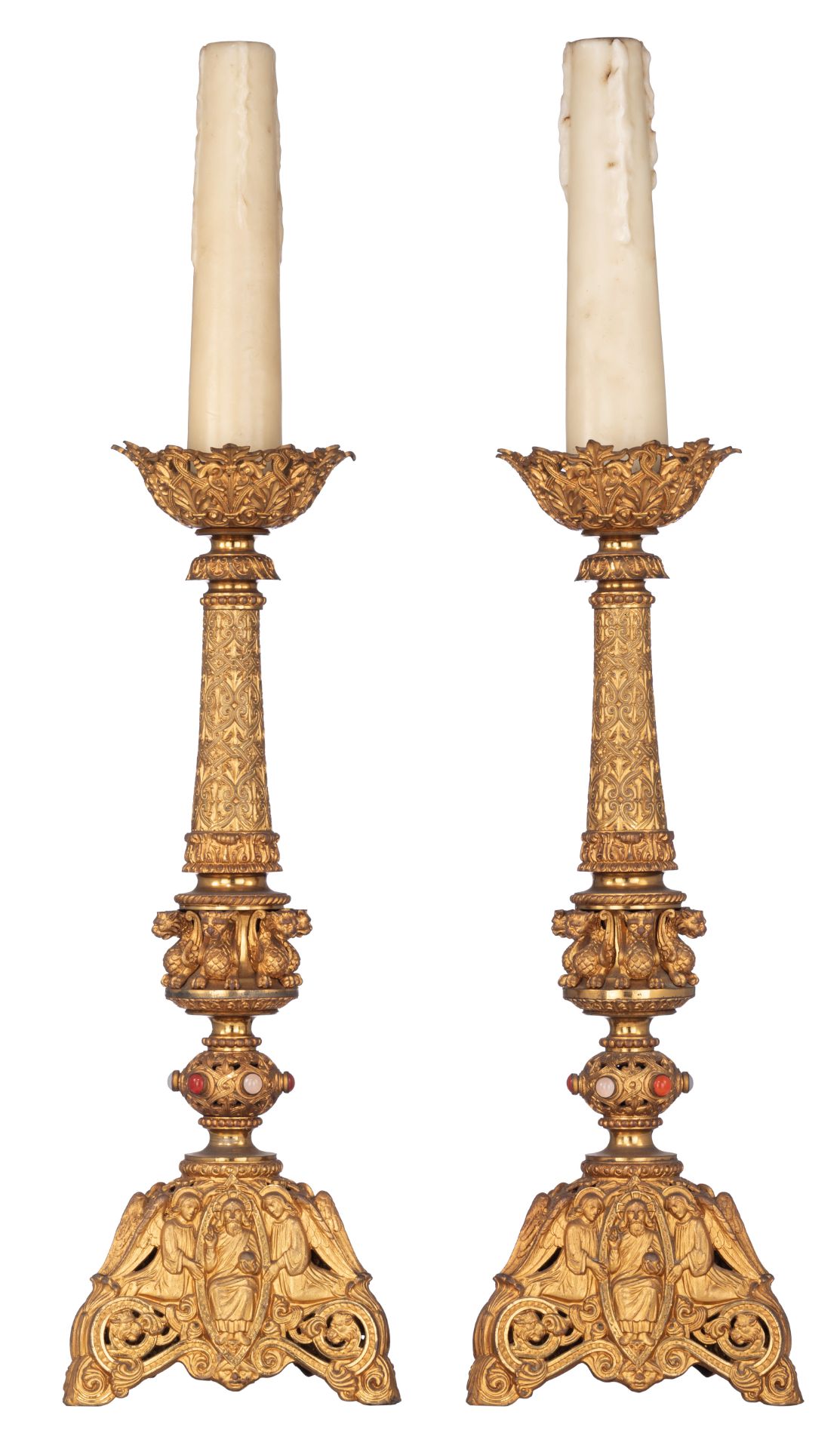 A pair of gilt bronze Romanesque inspired horror vacui candleholders, decorated with semi-precious s