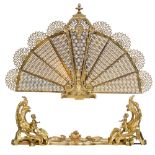 A brass Victorian style fan-shaped fire screen, decorated with Neoclassical ornaments and on top a m