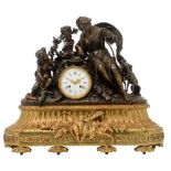 A gilt bronze mantle clock decorated with hunting trophies, with on top a patinated bronze group dep