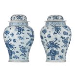 A pair of Chinese blue and white covered vases, decorated with flower baskets and antiquities, 20thC