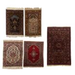 A collection of five Oriental woollen rugs, consisting of two prayers rugs, 98,5 x 148,5 / 99,5 x 13
