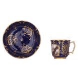 A Russian SŠvres style bleu royale ground and gilt decorated porcelain cup and saucer, the front rou