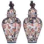 A large and imposing pair of Japanese Imari inspired Samson vases with covers, decorated with garden