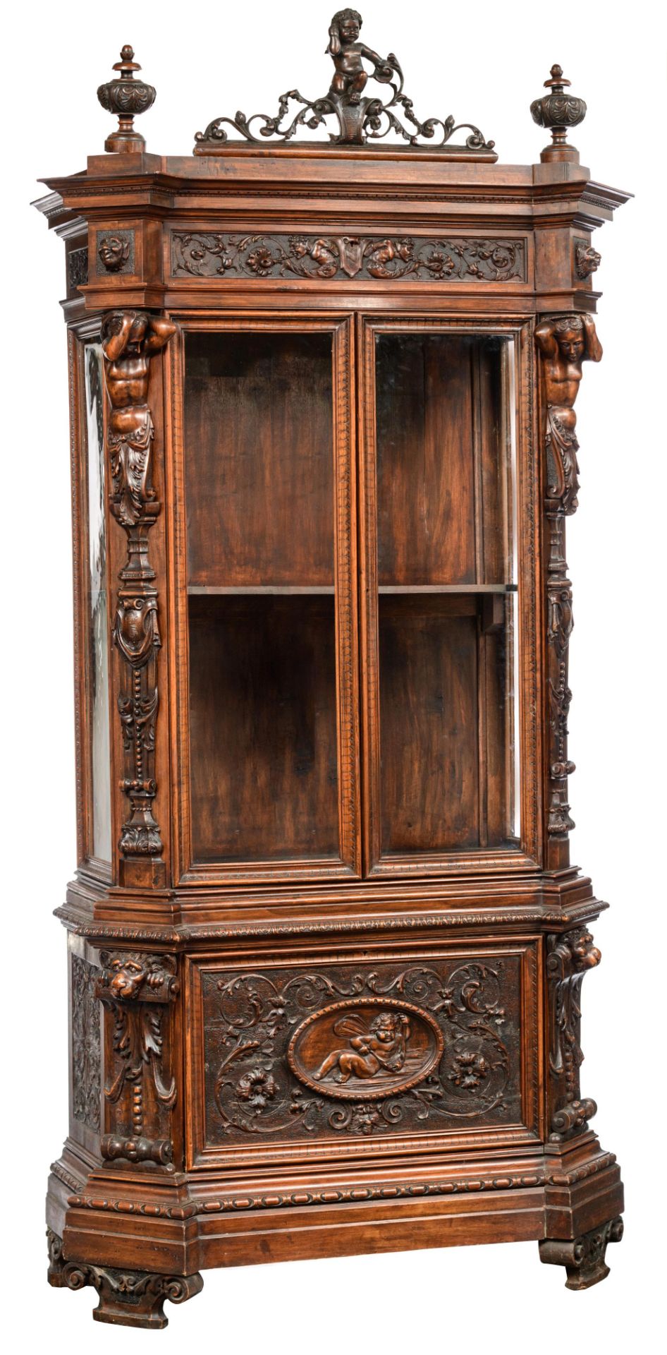 A richly sculpted walnut Renaissance style display cabinet, decorated with scrollwork, lion heads an