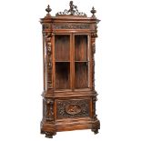 A richly sculpted walnut Renaissance style display cabinet, decorated with scrollwork, lion heads an