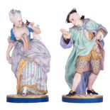 A large pair of French polychrome and gilt painted biscuit figurines of two lovers on a Venetian mas