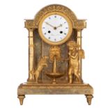 A gilt bronze Directoire table clock, with an angel teaching a dog a trick, in an antique setting wi