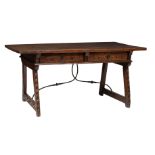 A Spanish Baroque walnut trestle (desk) table, decorated with carved geometric and stylized vine mot