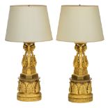 A fine pair of gilt bronze Empire style columns with lamps, in the manner of Thomire, decorated with