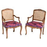 A fine pair of richly carved walnut Louis XV period armchairs, the seating upholstered with floral d