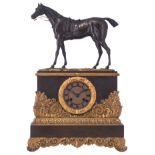 A French Restauration mantel clock, with on top a racing horse, H 51 - W 34,5 cm