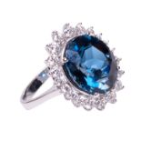 An 18ct white gold ring, central set with a London Blue Topaz (7.00ct) and 20 brilliant-cut diamonds