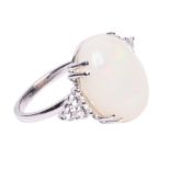 An 18ct white gold ring, central set with an oval opal and brilliant-cut diamonds, total weight: 7,4