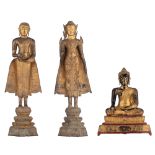 Two gilt bronze standing Buddha and a lacquered and gilt wood seated Buddha, Thailand, Tallest H 121