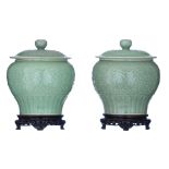 A pair of Chinese celadon glazed 'Lotus' covered jars, H 27,5 - ø 23,5 cm