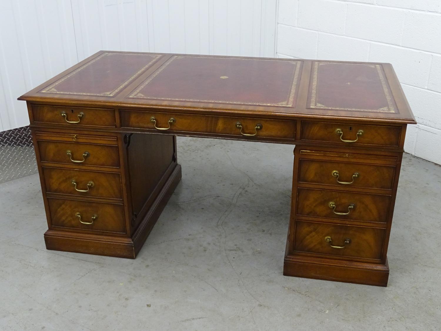 Partners Desk - a 20th C mahogany pedestal desk with gold tooled red leather inserts to top, with