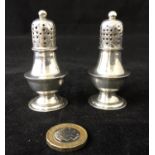 A pair of personal H M Silver Shakers - a pair of personal pepperettes of pedestal form clearly