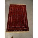Rug / carpet - a hand made woolen carpet with wine red ground with central cross and geometric