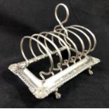 Ornate H M Silver Toast Rack - a four ball and claw footed 6 division toast rack with gadrooned edge