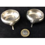 H M Silver - a pair of circular three footed salts with beaded edge decoration by the early