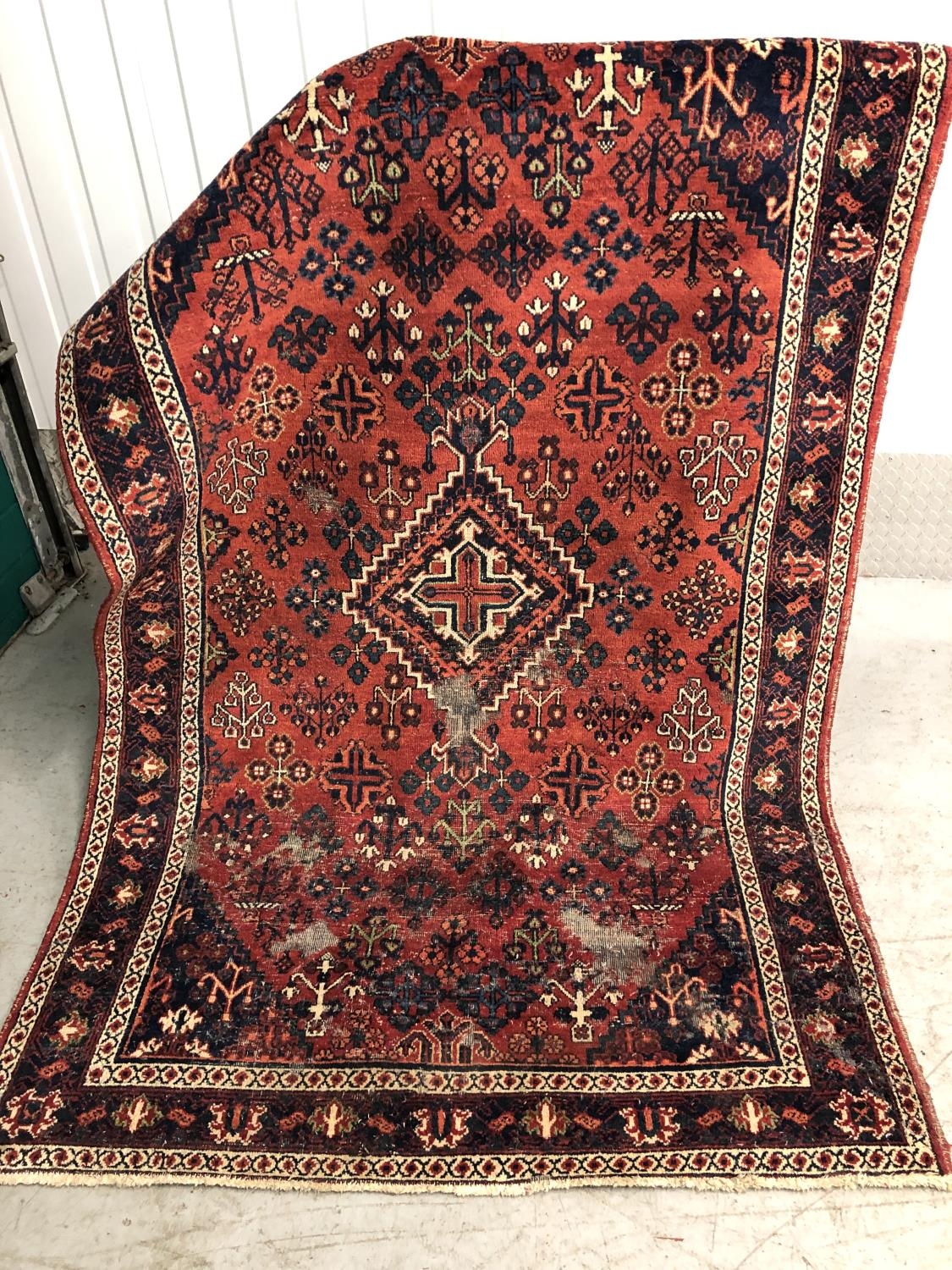 9 (L 249) Rug / carpet - a hand made wollen carpet with wine red ground with central cross and