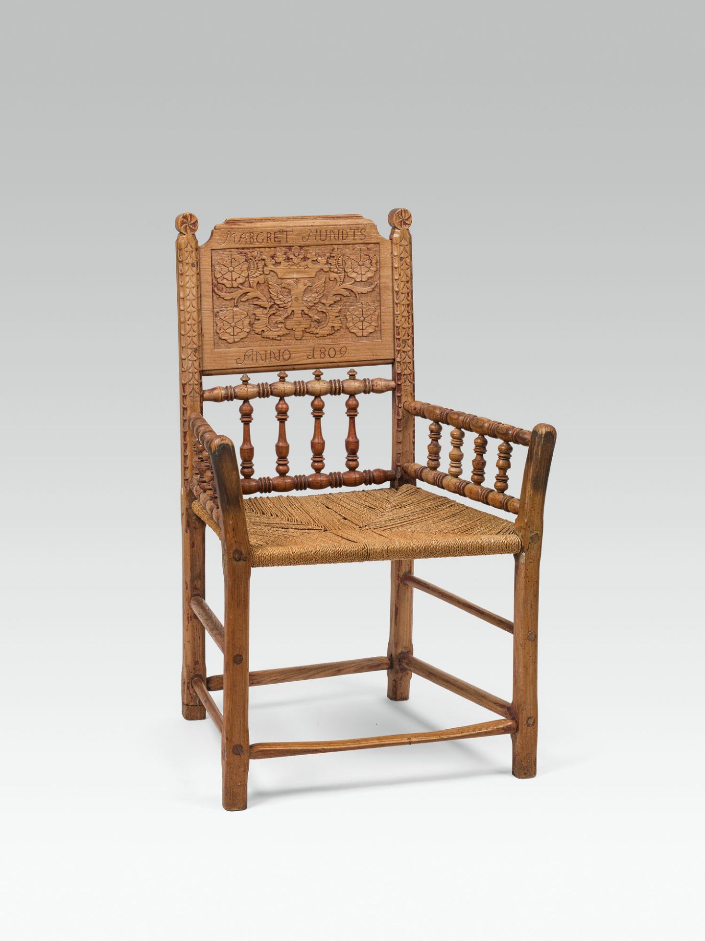 Armchairoakwood; seating surface of rush-mesh; backrest with textured carving decor; inscribed and