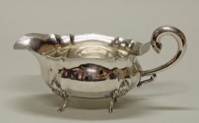 Saucière, Silber 830, gliedernde Züge, volutierter Henkel, vier Füße mit Lorbeer, 12 x 23 x 10.