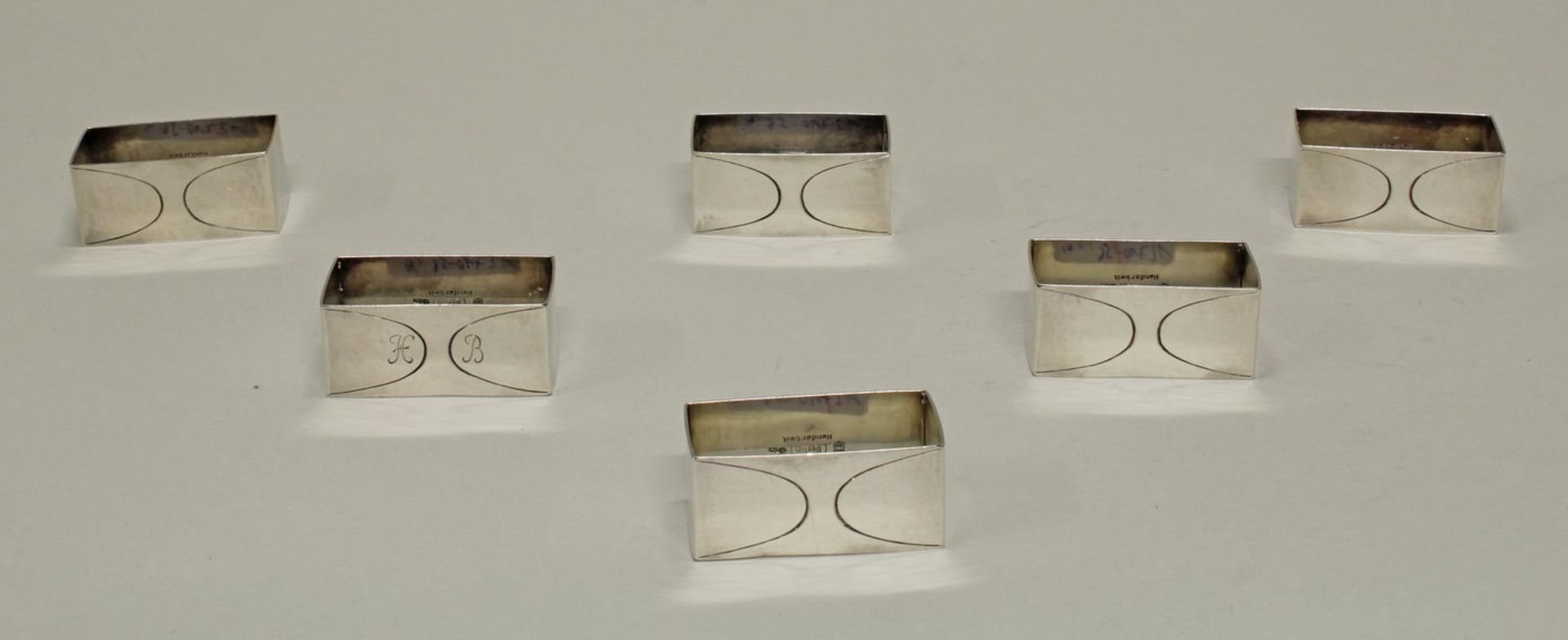 6 Serviettenringe, Silber 925, Berlin, H.J. Wilm, rechteckig, nummeriert bzw. 1x Monogramm, 2.5 x 5